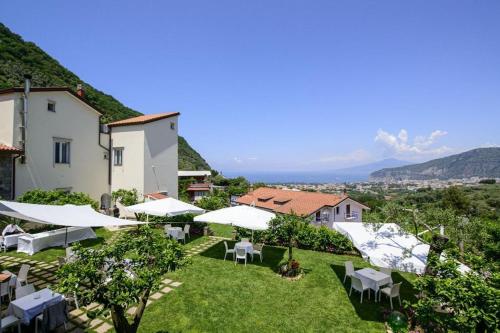 a view of a hotel with tables and white umbrellas at Casale Guarracino in Sant'Agnello