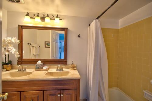 a bathroom with a sink and a mirror and a tub at Alii Villas Cozy 1BR Unit Near DT (5 Guests) in Kailua-Kona
