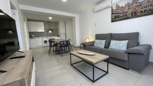 a living room with a couch and a table at Apartamentos Lusitania Parking Gratis bajo disponibilidad in Mérida