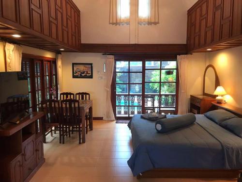 a bedroom with a bed and a kitchen and a dining room at Bungalow Phuket in Kamala Beach