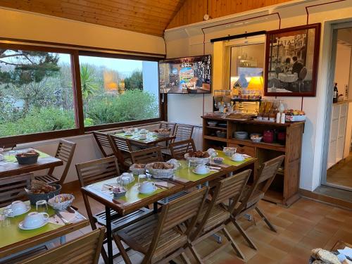 a dining room with tables and chairs in a kitchen at Hotel Aux Tamaris in Sauzon