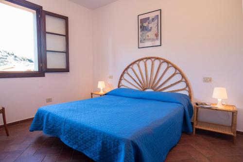 um quarto com uma cama azul e uma janela em BORGO PATRESI MARE 3 em La Guardia