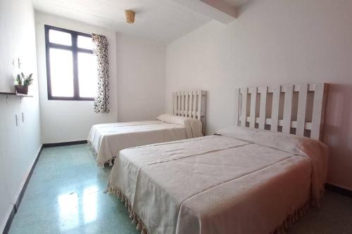 um quarto com 2 camas e uma janela em Casa Corazón em Oaxaca de Juárez