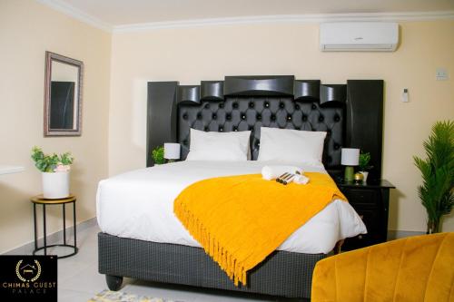 um quarto com uma cama grande e um cobertor amarelo em Chimas Guest House em Musina