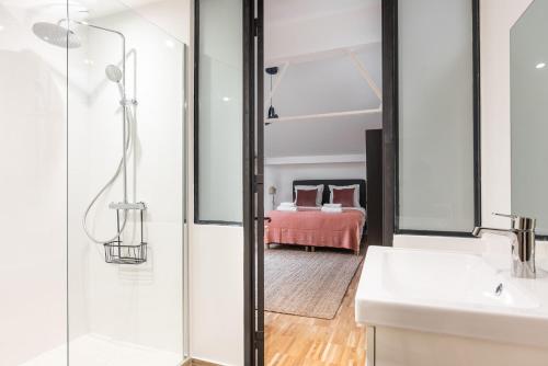 une salle de bain avec une douche et un lavabo et un lit dans l'établissement Fantastic Architect Loft for 10 guests near Metro, à Paris