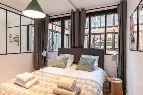 - une chambre avec un grand lit et des fenêtres dans l'établissement Fantastic Architect Loft for 10 guests near Metro, à Paris