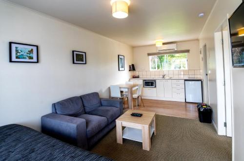 a living room with a couch and a table at Ripple Rotorua in Rotorua