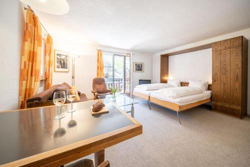 a room with a bed and a table with wine glasses at 2303 Einfaches und guenstiges Studio in Vulpera
