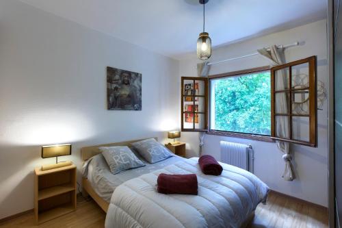 een slaapkamer met een bed en een raam bij Villa Rodolphe 8 in Le Pian-Médoc