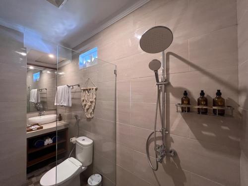 a bathroom with a shower and a toilet and a sink at Grand Yuna Hotel Nusa Penida in Toyapakeh