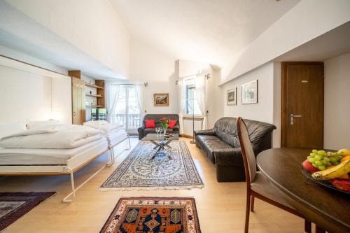 a living room with a bed and a couch at 2403 Charmante Dachwohnung mit hohen Decken und Suedbalkon in Vulpera