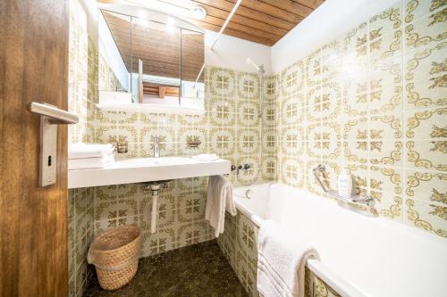 bagno con lavandino, vasca e servizi igienici di 2403 Charmante Dachwohnung mit hohen Decken und Suedbalkon a Vulpera