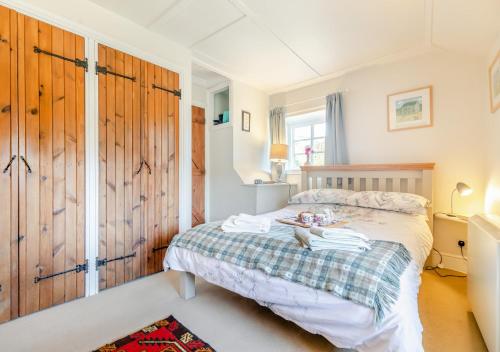 a bedroom with a bed with towels on it at Popigale Cottage in Helford
