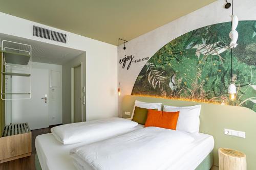 a bedroom with two beds and a painting on the wall at The Weekend Hotel in Vienna