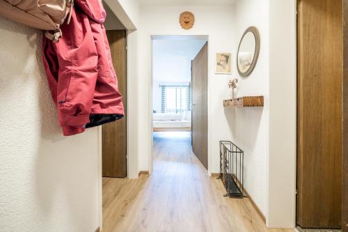a room with a hallway with a door and a coat hanging on a wall at 2404 Grosszuegige Maisonette Wohnung und Balkon mit atemberaubendem Talblick in Vulpera