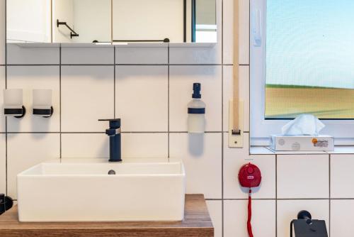 a bathroom with a white sink and a window at Ferienwohnung Romanas in Ostrach