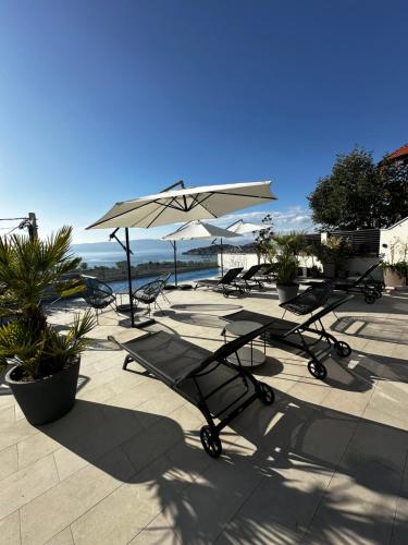 a group of chairs and tables with an umbrella at La Vista Luxury Villa in Ohrid