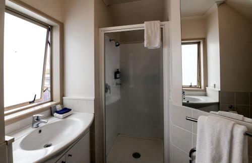 a bathroom with a shower and a sink and a tub at Ripple Rotorua in Rotorua