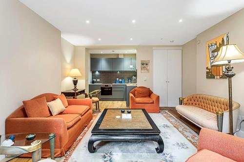 倫敦的住宿－Beautiful Abode in Kensington Olympia，客厅配有橙色家具和桌子