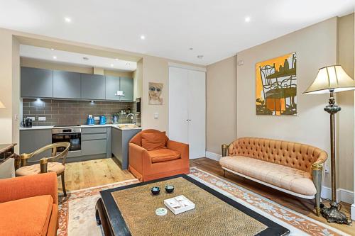 a living room with a couch a chair and a table at Beautiful Abode in Kensington Olympia in London