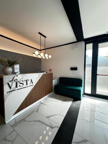 a living room with a green couch and a window at La Vista Luxury Villa in Ohrid