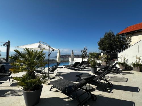 a group of lounge chairs and umbrellas on a patio at La Vista Luxury Villa in Ohrid