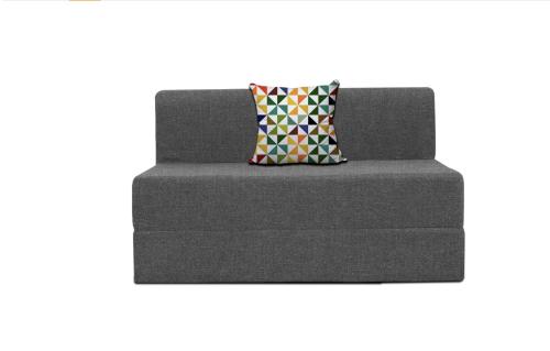 a gray couch with a colorful pillow on it at Homlee-Jumbo 1BHK-2AC-Kitchen-Lift-Parking-Tapovan in Rishīkesh
