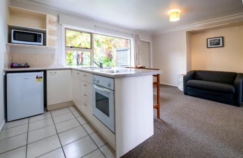 a kitchen with a counter and a couch in a room at Ripple Rotorua in Rotorua