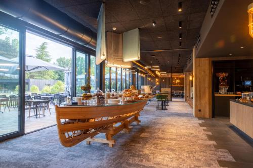 a restaurant with a long table and chairs and windows at Miura in Voglans