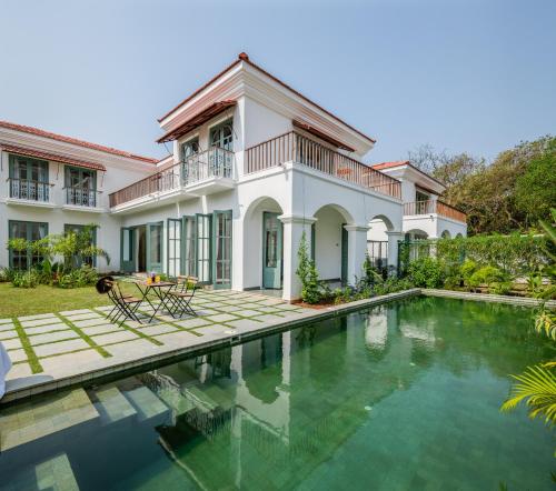 an exterior view of a house with a swimming pool at La Mosteiro by The Blue Kite - in Assagao, Splendid 3&4BHK Villas with Private Pool, Private Parking, Garden, Caretaker, Kitchen & Security in Vagator