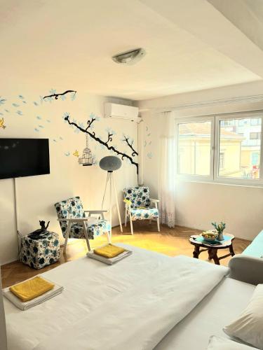 a living room with a couch and a tree branch on the wall at Center Apartment in Višegrad