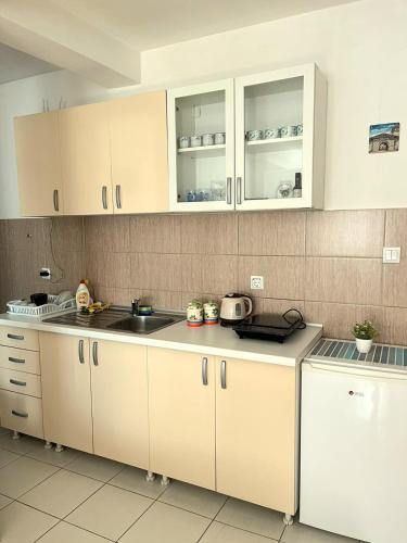 a kitchen with white cabinets and a sink at Center Apartment in Višegrad