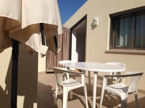 einen weißen Tisch und Stühle auf dem Balkon in der Unterkunft Figueira Praia Buarcos in Figueira da Foz