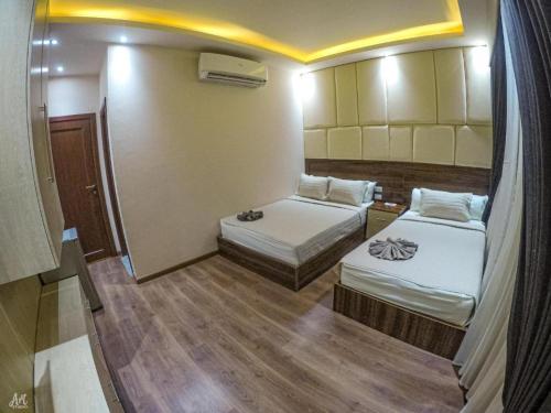 um pequeno quarto com duas camas em Elite Grand City no Cairo
