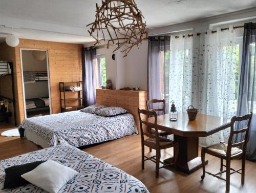 een slaapkamer met 2 bedden en een tafel en een eetkamer bij Domaine de la Caure in Bussière-Dunoise