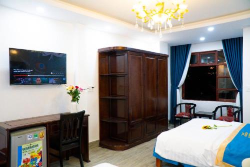 a bedroom with a bed and a cabinet and a desk at Huong Mai Hotel in Da Lat