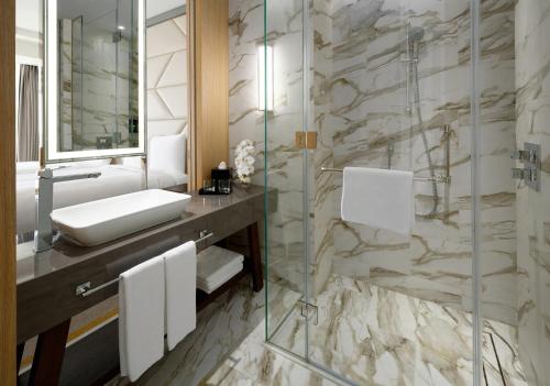 a bathroom with a sink and a glass shower at Crowne Plaza - Jeddah Al Salam by IHG in Jeddah