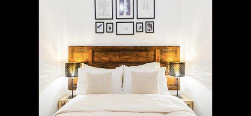 ローマにあるEsquiline Suitesのベッドルーム1室(ベッド1台、ランプ2つ、壁に絵画付)