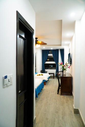 a hotel room with a bed and a hallway with a door at Huong Mai Hotel in Da Lat