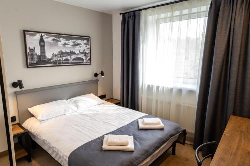 1 dormitorio con 1 cama con 2 toallas en A presto, en Vínnytsia
