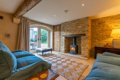 a living room with a couch and a fireplace at Coach House, Cold Aston in Bourton on the Water