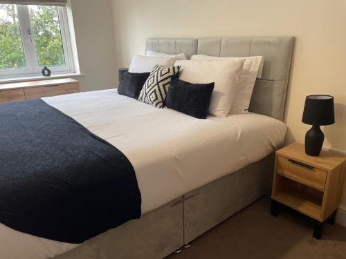a bedroom with a large bed with white sheets and pillows at 2 Cherry Tree Cottages in Stock