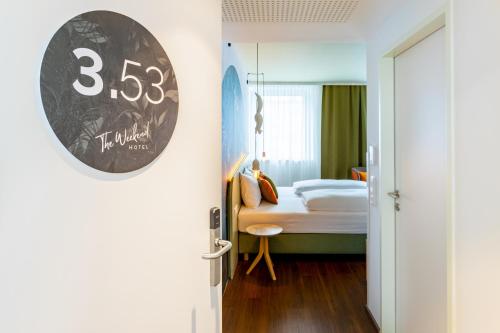 a room with a bed and a clock on the wall at The Weekend Hotel in Vienna