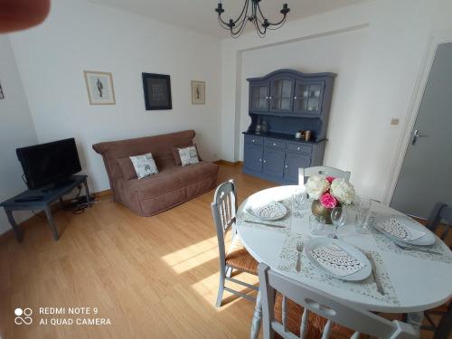 ein Wohnzimmer mit einem Tisch und einem Sofa in der Unterkunft Les 26 Tanneurs appartement in Noyon