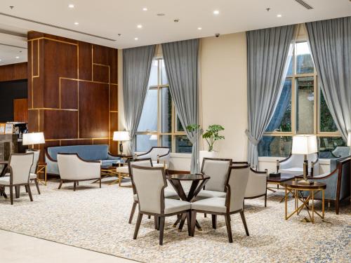 a hotel lobby with chairs and tables and windows at Wirgan Hotel Al Nour in Makkah