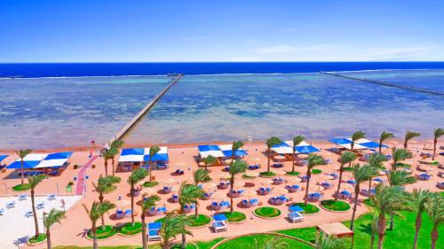 Pickalbatros Royal Moderna Sharm "Aqua Park" في شرم الشيخ: اطلالة جوية على شاطئ فيه كراسي ومظلات