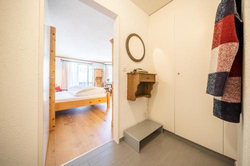 a small bedroom with a bed and a mirror at 3304 Preislich attraktives Studio im alpinen Stil in Vulpera