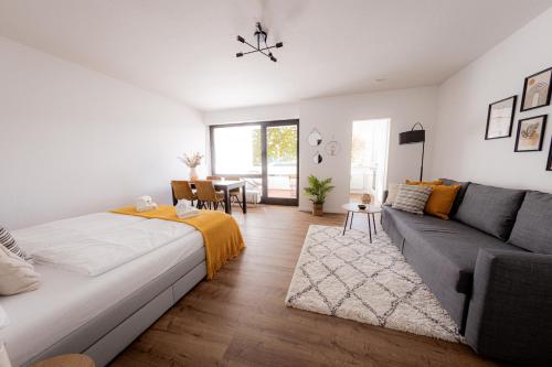 a living room with a bed and a couch at Come4Stay Passau - Apartment Seidenhof I voll ausgestattete Küche I Balkon I Badezimmer in Passau