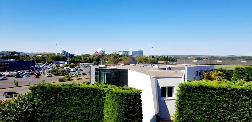 a view of a building with a parking lot at Kyriad Direct Poitiers - Gare du Futuroscope in Chasseneuil-du-Poitou