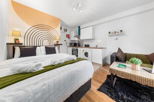 a bedroom with a large bed and a kitchen at Modern Studio in Central Brixton, Stylish, Fast Wi-Fi & Parking in London